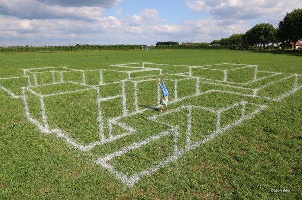 Anamorphosis chalk on grass by Leon Keer